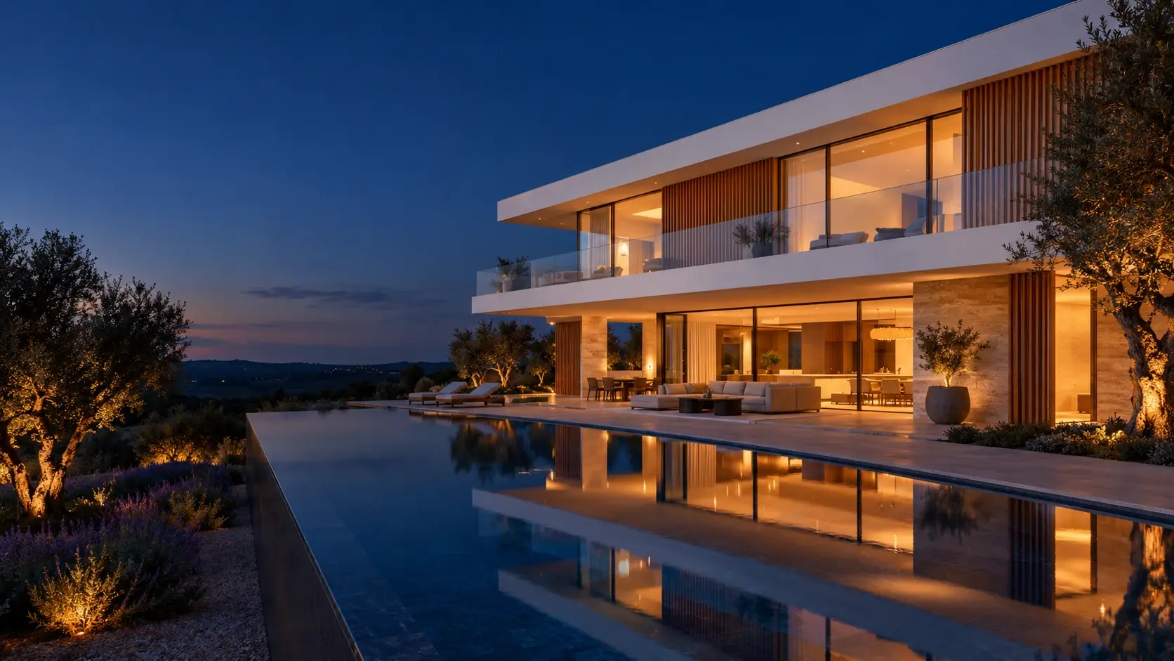 Villa contemporánea con piscina desbordante, olivos y luz cálida al anochecer