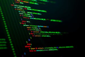 Código de programación desenfocado en pantalla oscura, representando agentes de programación como Codex, Claude Code y Kimi Code